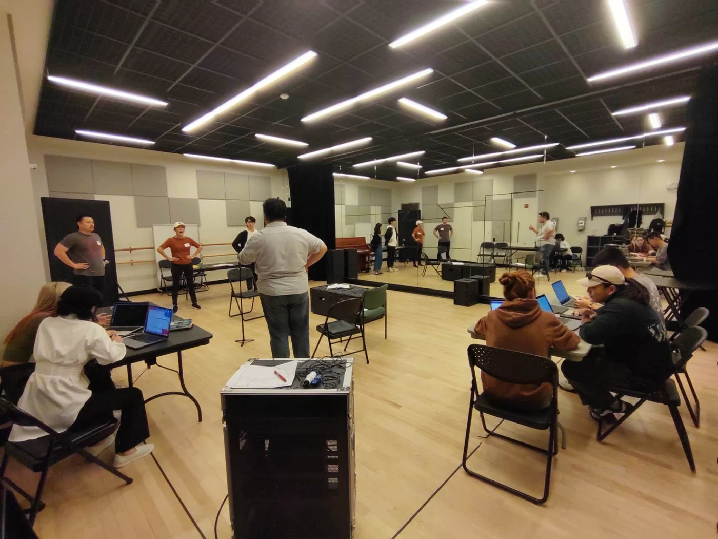 Performers working together in a theatre rehearsal room.